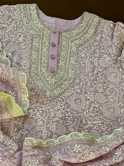 A close-up of the buttoned placket and neckline of the lilac Anarkali, revealing the precision of the hand-stitched details.