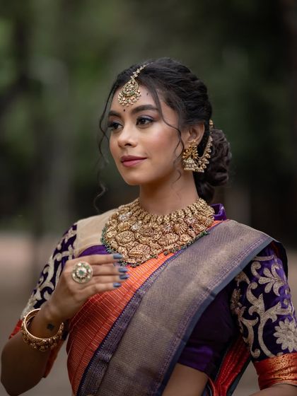 A beautiful portrait capturing the model's elegant profile and the rich details of her blouse and jewelry.