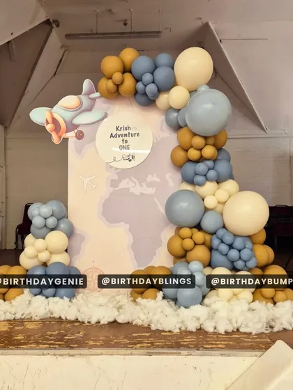 An "Adventure to One" party with a vintage airplane theme. The world map backdrop and the "clouds" made of fiber fill at the base are creative touches.