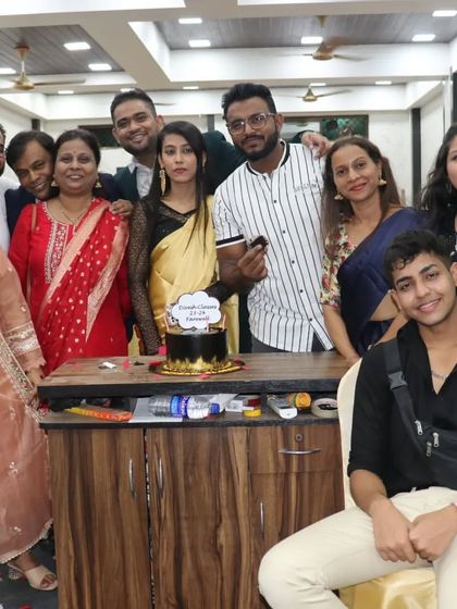 The entire team and students pose for a group photo around the farewell cake, capturing a happy memory.