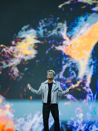 An artist stands before a massive, abstract explosion of color on the main LED screen. This demonstrates our ability to create powerful, artistic visuals that serve as a stunning backdrop for performers.