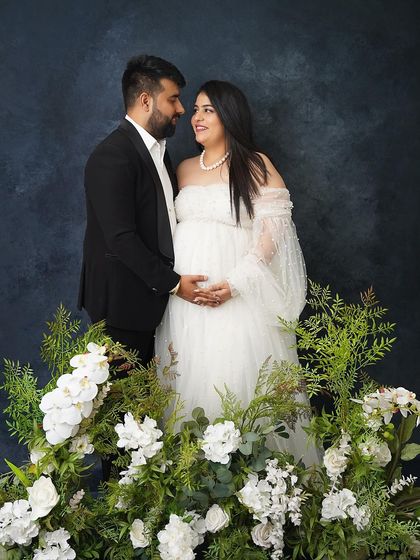 A classic couple's portrait surrounded by white flowers. The greenery and white blooms create a fresh, elegant, and timeless look.