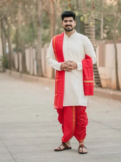 A welcoming and happy portrait of the groom. His hands joined in a gesture of respect, he looks ready and excited to begin the wedding ceremonies.