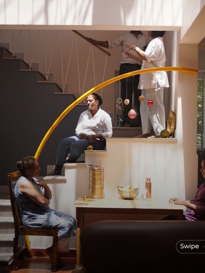 Family members interacting in the multi-level living space of the Gopal Residence. The design with its split levels and open staircase encourages connection and communication.