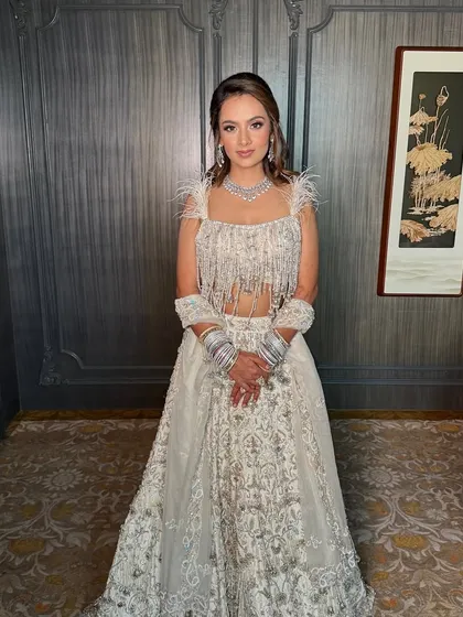 A full-length view of this stunning look for the sister of the groom. The intricate white lehenga is paired with soft, elegant makeup and hair for a perfectly balanced ensemble.
