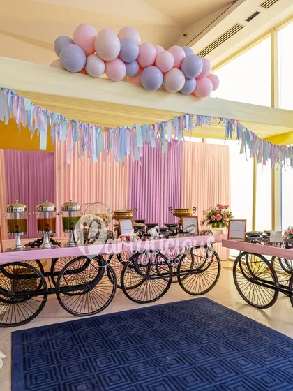 The food and drink station for a dreamy, pastel-themed event. We used food carts, draped fabrics, and a soft balloon garland overhead to create a cohesive and beautifully styled area for guests to enjoy.