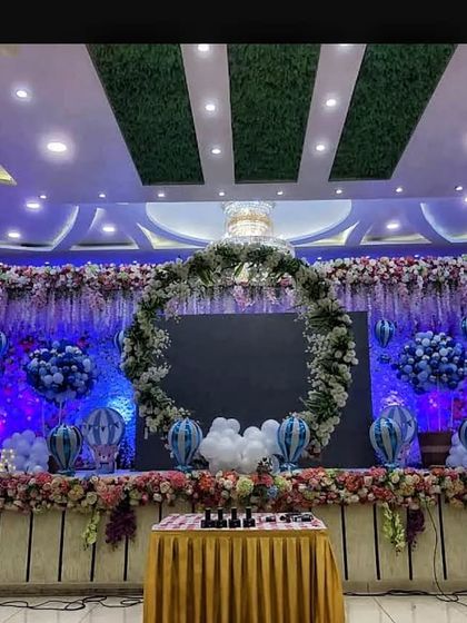 A beautiful naming ceremony or baby shower decoration at Akshata banquet hall. The large floral wreath on the stage creates an elegant and celebratory focal point.