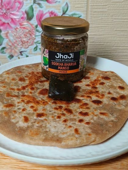 A tempting combination of a hot, flaky paratha topped with a piece of our Sookha Bharua Mango pickle. A classic and beloved pairing.