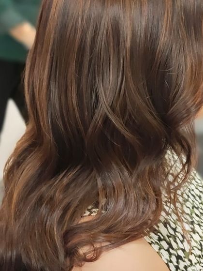 A side view showcasing the glossy finish and seamless blend of colours. Her hair looks healthy, vibrant, and full of life.