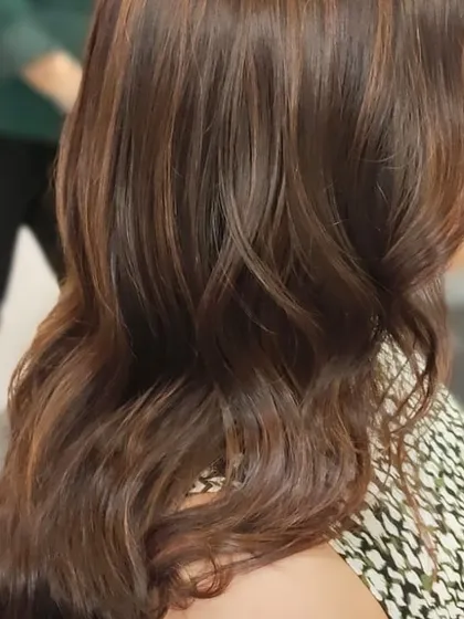 A side view showcasing the glossy finish and seamless blend of colours. Her hair looks healthy, vibrant, and full of life.