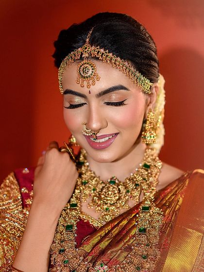 A close-up capturing a bride's blissful expression. This shot provides a detailed look at the muhurtham makeup, with soft pink lips and shimmering eyeshadow.