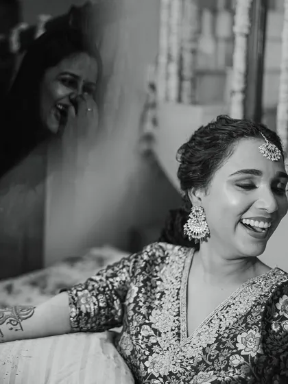 A black and white photo capturing the joy between our bride and stylist during the Mehendi. It reflects the trust and connection we build, which is the secret to a successful virtual styling project.