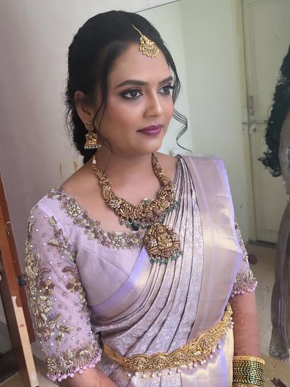Another angle of Kavyashree's stunning reception look. The heavily embroidered blouse and antique-finish jewelry are balanced by a polished updo and flawless makeup.