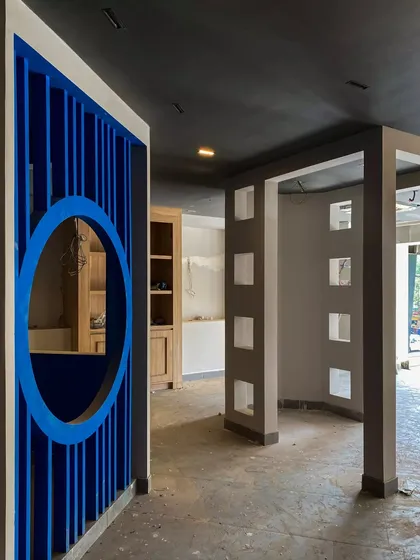The architectural shell of the Weatherseal project during construction. Here you can see the raw forms of the display partitions and the striking blue circular entryway before the final finishes are applied.