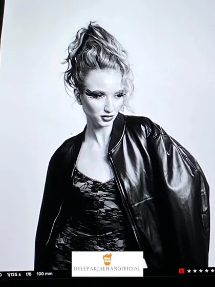 A black and white shot from the HBS Magazine 2025 photoshoot. The high-fashion ponytail, dramatic eye makeup, and leather jacket combine to create a bold and powerful editorial image.