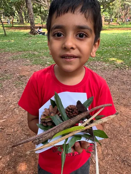 A handful of natural wonders. This young participant shows off his collection of leaves, sticks, and pinecones gathered during our foraging activity. Each item tells a story and connects him to the environment.