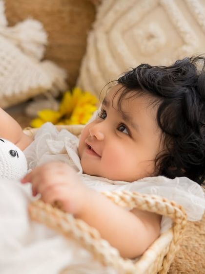 A lovely profile shot of the baby in her bassinet, capturing her sweet expression and the soft, natural textures of the setup.