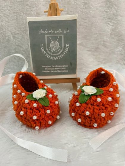 Another look at the cheerful orange pearl and rose booties, showing the detail of the embellishments.