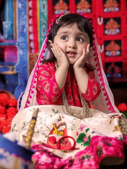 Capturing the wonder in a child's eyes is what I do best. This little girl, dressed as Radha, has a look of pure awe, making for a truly magical and candid festival photograph.