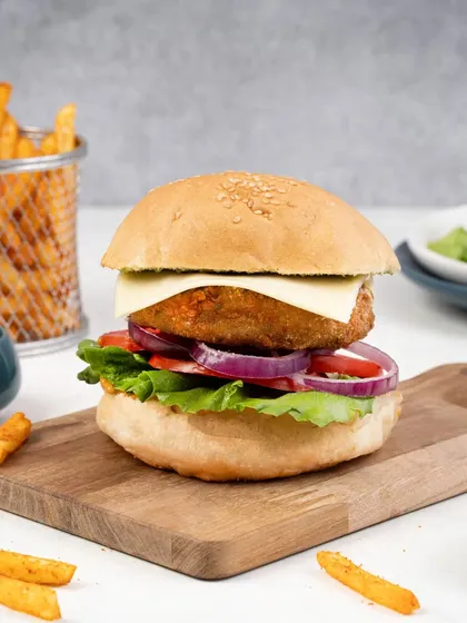 A deconstructed burger shot helps showcase the quality of each ingredient. This image is perfect for a menu, showing the juicy patty, fresh vegetables, and melted cheese before the burger is fully assembled.