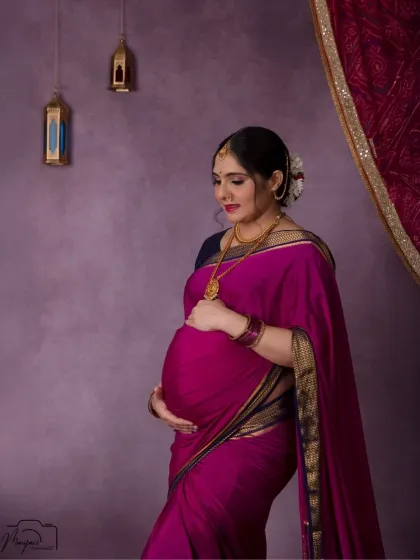 A beautiful close-up, focusing on her gentle touch on the baby bump and the intricate details of her traditional jewelry and hairstyle.