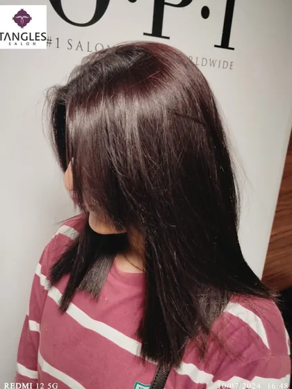 This image showcases a beautiful, deep mahogany global color on medium-length hair. This shade has subtle red undertones that add warmth and richness, creating a sophisticated and modern style.