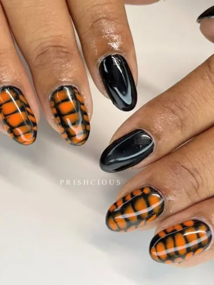 A cool Halloween-inspired set using blooming gel to create this orange tiger-stripe effect on the client's natural nails.