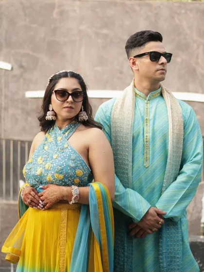 A cool shot of the couple in sunglasses. The bride's makeup is chic and modern, a perfect fit for their stylish Haldi party.