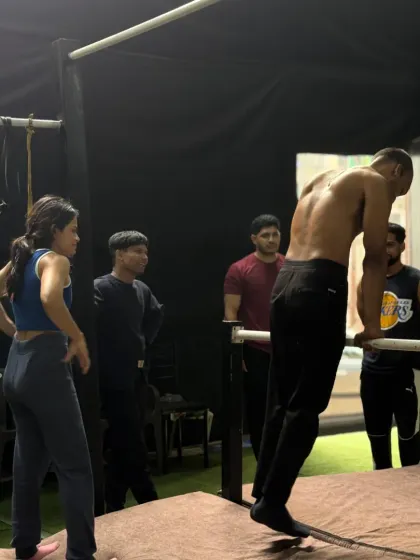 Another angle of a coach spotting a member on the dip bars. The entire group watches and learns.