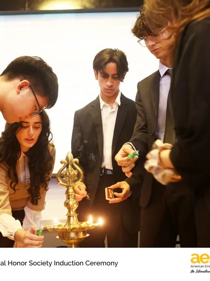 Students participate in the traditional lamp lighting ceremony during the National Honor Society induction. This symbolizes the pursuit of knowledge and the four pillars of NHS: scholarship, leadership, service, and character.