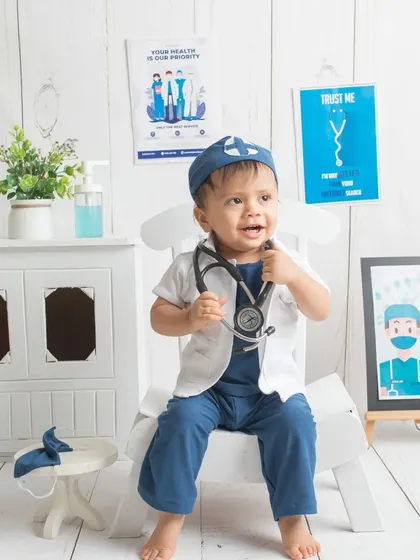 Listening closely with his stethoscope. This action shot adds a playful narrative to the doctor-themed session.