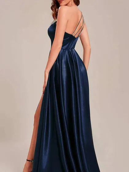 The back view of the navy one-shoulder satin gown, showcasing the delicate multi-strap detail that adds a unique touch to the open back.