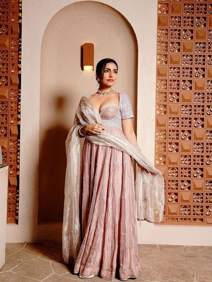 A classic pose showing off the full Anarkali gown. The clean, low bun and subtle makeup create a look of timeless grace.