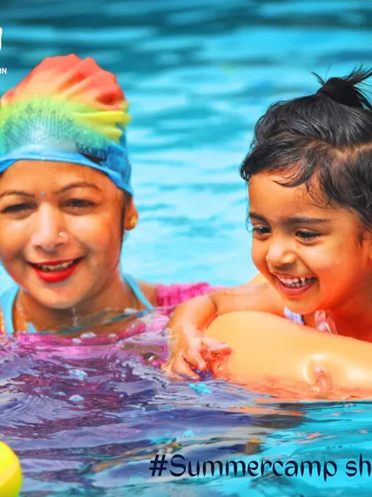 A moment of pure happiness between a coach and a young camper. Our instructors create a nurturing environment, ensuring every child feels supported while learning to swim and having fun on a float.