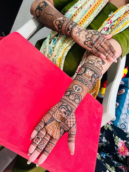 A happy mom-to-be showing off her full baby shower mehendi. The design is a beautiful celebration of the new life she is bringing into the world.