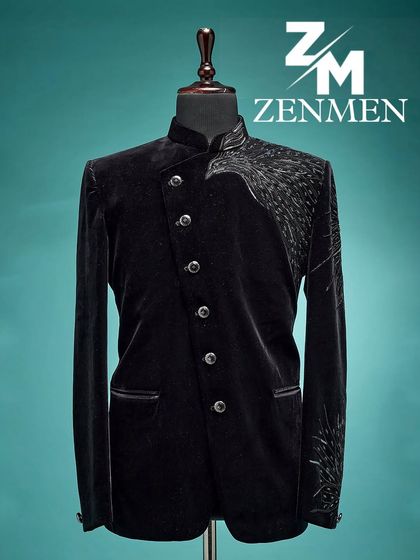 A full view of the black velvet Jodhpuri with asymmetrical silver wing embroidery. The angled button placket adds to its modern, edgy design.