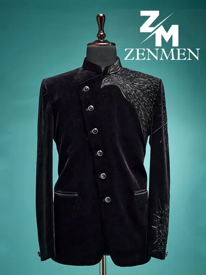 A full view of the black velvet Jodhpuri with asymmetrical silver wing embroidery. The angled button placket adds to its modern, edgy design.