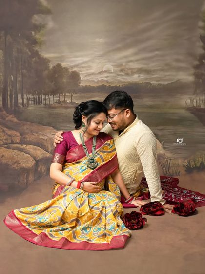 A romantic couple's portrait with a painted backdrop. The traditional attire and classic pose create a feeling of a timeless love story.