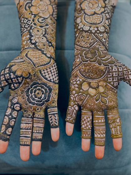 A close-up of the palms, featuring a mix of floral and traditional Indian patterns with full finger coverage.