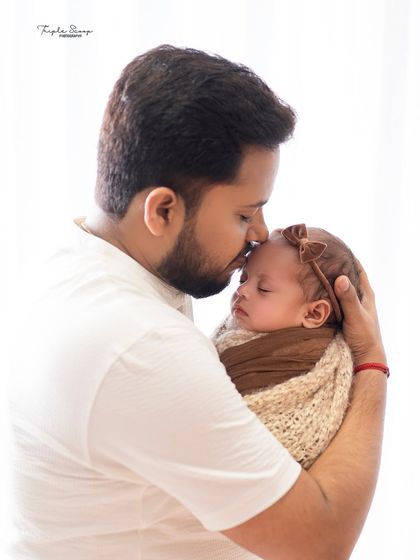 A father's gentle kiss for his newborn. Capturing the bond between a dad and his new baby is always a special part of my newborn sessions.