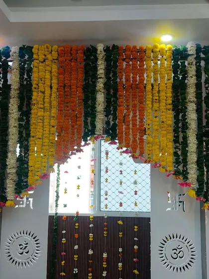 A beautiful marigold curtain (parda) used to decorate a large doorway or window at home. The multi-colored garlands add a vibrant touch.