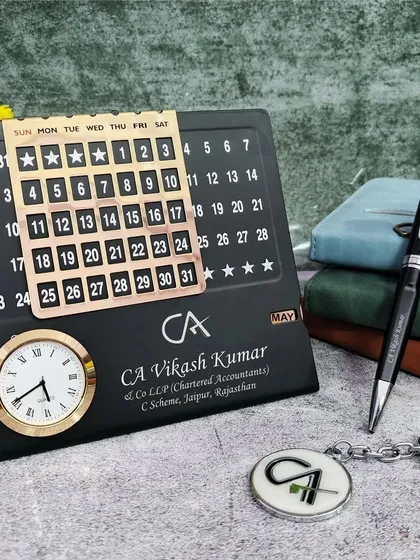 For professionals, I create themed mini combo sets like this one for a Chartered Accountant. It includes a metal infinite calendar with a clock, a pen, and a keychain, all featuring the CA professional logo and custom name engraving.