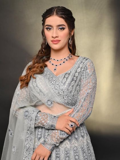 This grey lehenga with all-over embroidery offers a sophisticated and understated look. The full sleeves and classic cut make it a timeless choice for any formal occasion.