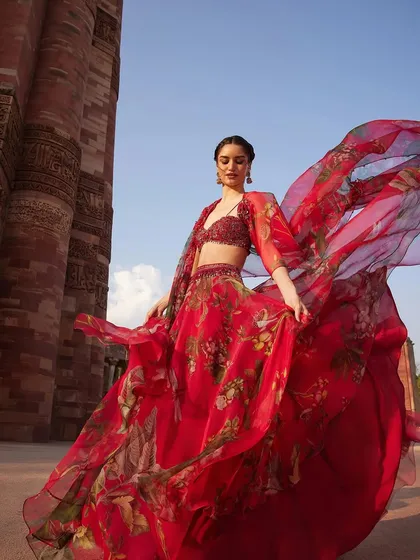A moment of pure drama and elegance. This flowing red floral lehenga is designed for the woman who owns every room she enters, perfect for a grand wedding celebration or a special occasion.