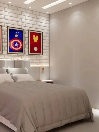 A close-up of the bed with its upholstered headboard and minimalist superhero art prints.