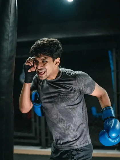A fighter shows intensity and determination while training on the heavy bag.