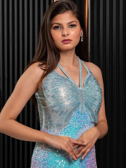 A full-length view of our iridescent sequin gown. The way it catches the light is simply mesmerizing, making it the ultimate party dress for a night of celebration.