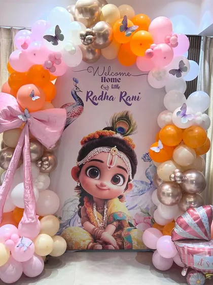 We created this unique 'Radha Rani' theme to welcome a new baby girl. The decoration includes a beautiful custom backdrop, a colorful balloon arch in pink, orange, and rose gold, and delicate butterfly details, providing a special and traditional touch for the celebration.