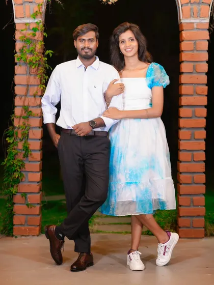 A classic portrait of a couple in a casual, relaxed setting. The brick arches and greenery provide a simple yet beautiful backdrop.