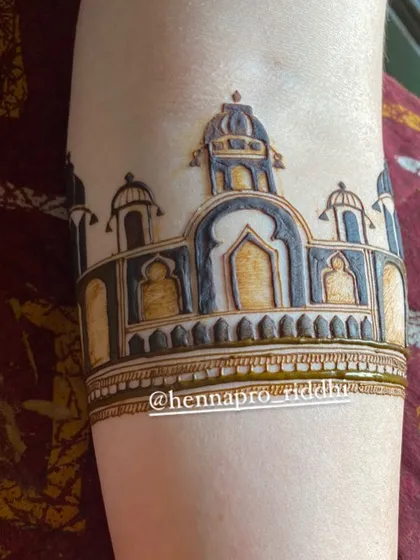 The beginning of a beautiful bridal arm design. This cuff features a detailed drawing of a palace, setting a grand and royal tone for the rest of the henna.